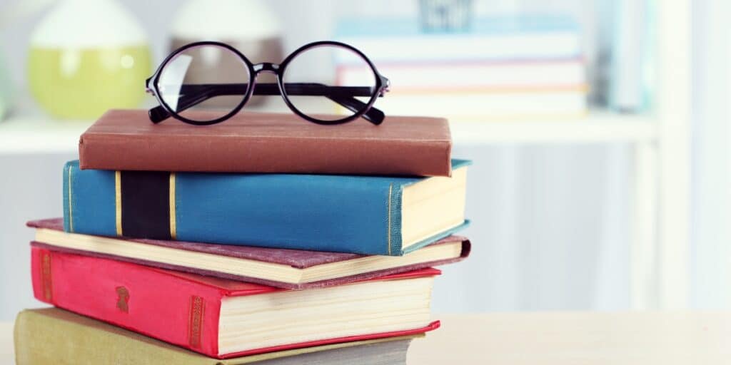 a pair of glasses on top of a stack of books