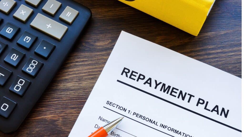 Reimbursement plan on a desk next to a calculator and pen