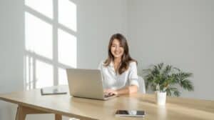 Side Hustles for Women: 20+ Best Flexible & Profitable Ideas 11 Woman working from home on a laptop in a bright minimalist office, representing modern side hustles for women and flexible work-from-home opportunities.