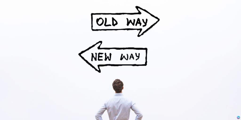 a person standing in front of an old way sign and a new way sign