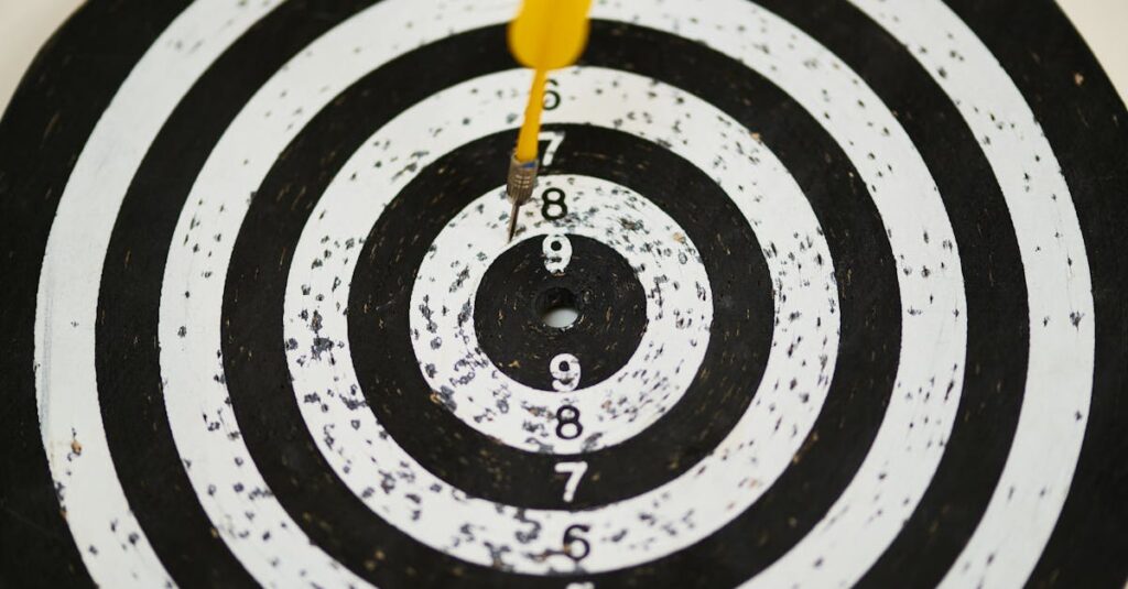 Close-up of a dart hitting the bullseye on a black and white target board symbolizing success.