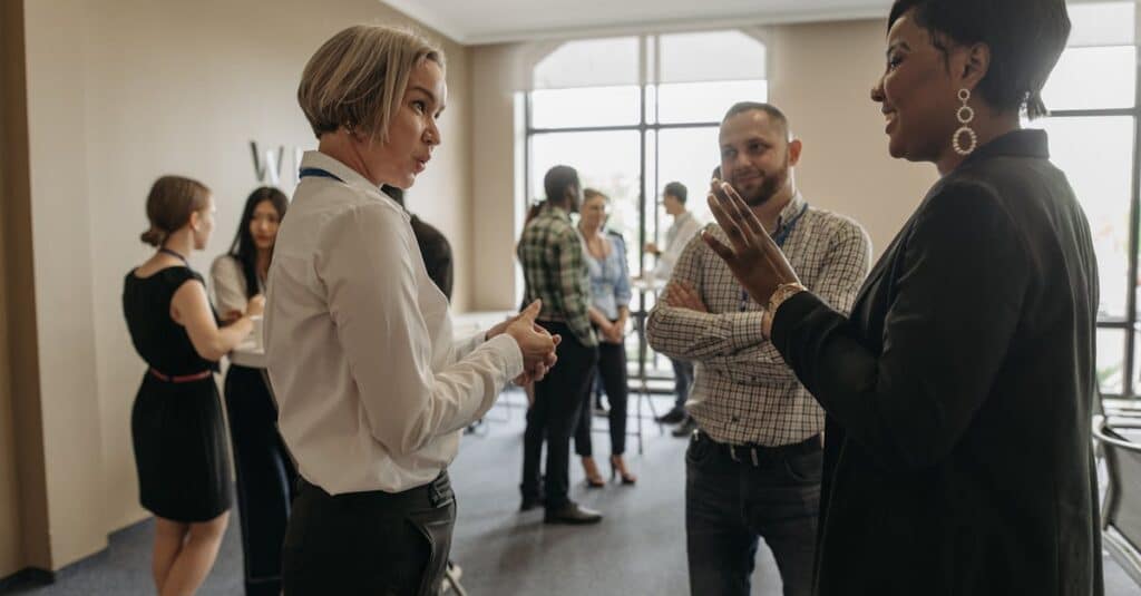 Professionals networking at a corporate event indoors, discussing and collaborating.