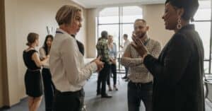 Professionals networking at a corporate event indoors, discussing and collaborating.