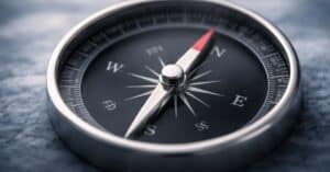 A close-up of a compass needle pointing north, representing direction, consistency, and trustworthy leadership.