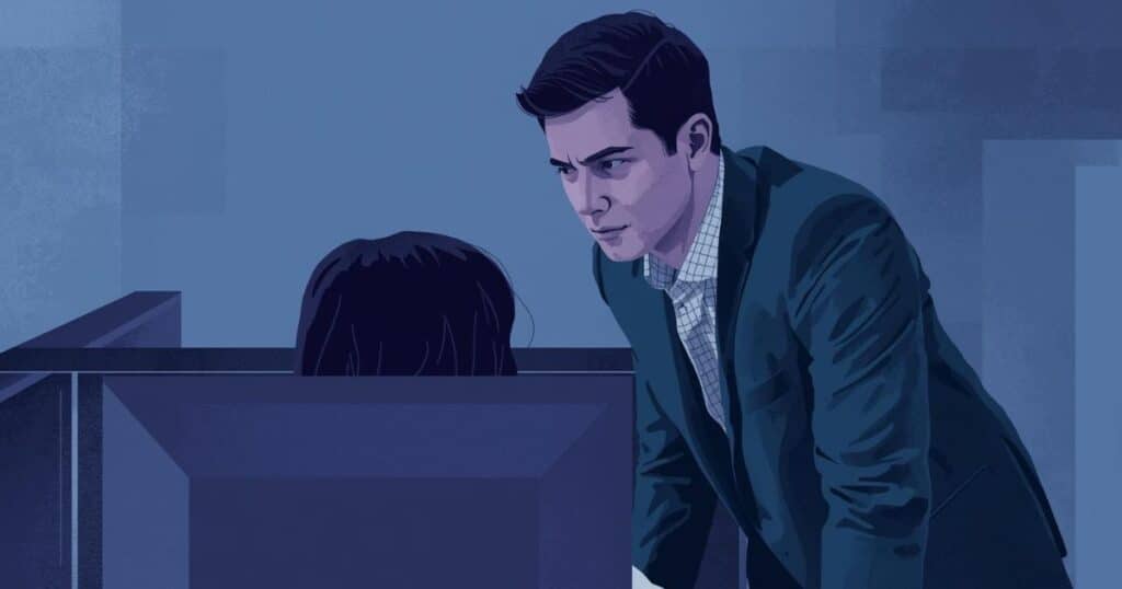 Manager looking over employee's shoulder at computer screen - micromanagement in the workplace