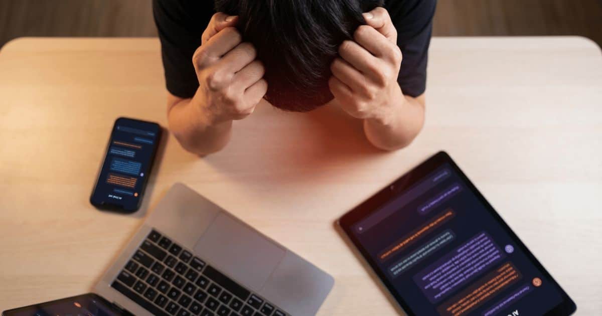 person's hands are pressing against their temples in visible mental strain.